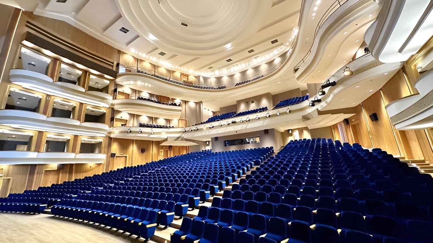 The main hall of the Palais des Arts et de la Culture, with its blue seats and curved balconies